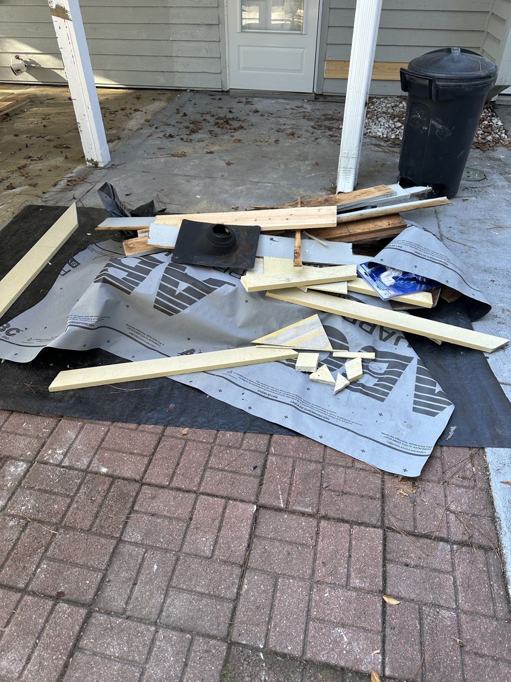 Debris and trash on a porch slab before pickup